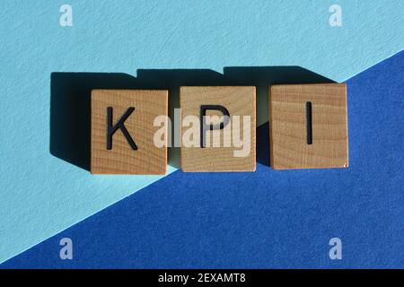 KPI technology acronym for Key Performance Indicator in wooden alphabet letters isolated on blue background Stock Photo