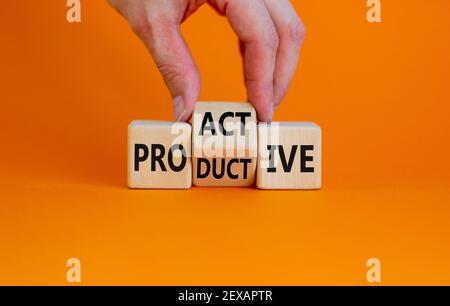 Proactive and productive symbol. Businessman turns cubes and changes the word 'productive' to 'proactive'. Beautiful orange background, copy space. Bu Stock Photo