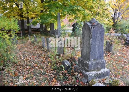 An old abandoned country cemetery in Orange, Pennsylvania, USA . Derelict tombstones and overgrown weeds. 10-10-2020 Stock Photo