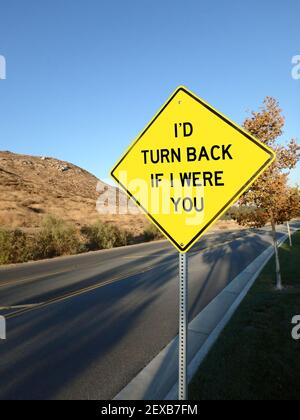 Yellow diamond road sign warning to turn back Stock Photo