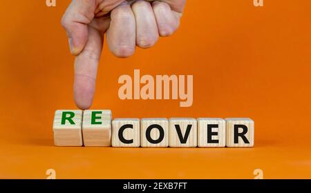 Time to recover symbol. Businessman turns wooden cubes and changes the word 'cover' to 'recover'. Beautiful orange background. Business, cover or reco Stock Photo