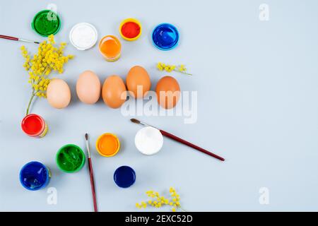Eggs and paints. Easter eggs decoration process. Copy space. Top view. Stock Photo
