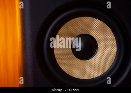 A black and gold coloured speaker cone.Shot with soft golden glow lighting. Stock Photo