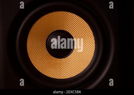 A black and gold coloured speaker cone.Shot with soft golden glow lighting. Stock Photo