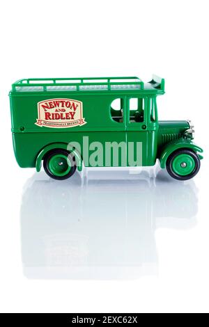 Worn diecast model of a vintage 'Newton and Ridley'' brewery charabanc. Isolated on a white background, with reflection. Stock Photo