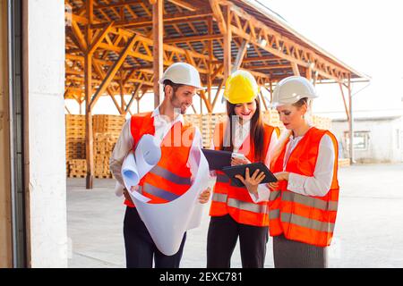 Team of young architects using tablet and blueprints Stock Photo
