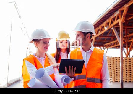 Team of expert architects on construciton site in helmets Stock Photo