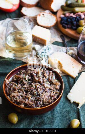 Wild rice salad surrounded by cheese board condiments and wine Stock Photo