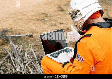 Man dressed as astronaut using laptop Stock Photo