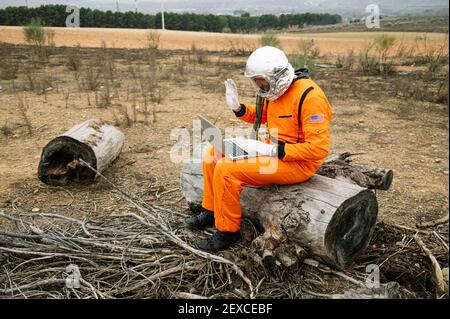 Man dressed as astronaut using laptop Stock Photo