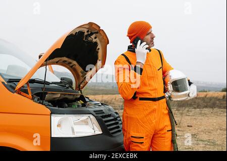 Man dressed as astronaut using smart phone Stock Photo