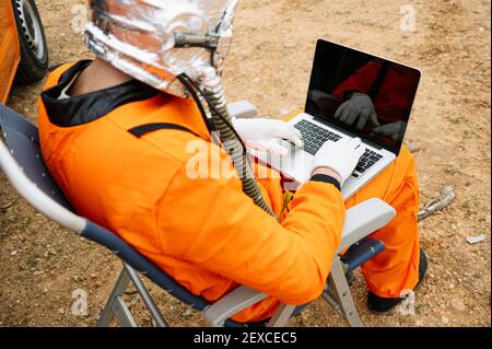 Man dressed as astronaut using laptop Stock Photo