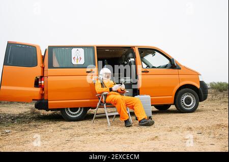 Man dressed as astronaut using smart phone Stock Photo