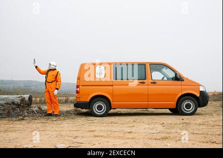 Man dressed as astronaut using smart phone Stock Photo