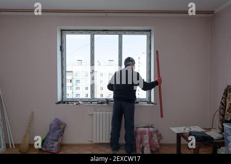 Tiraspol, Moldova - March 2, 2021: Installation of windows. The builder installs a pvc window brand WDS in the apartment of an apartment building. Stock Photo