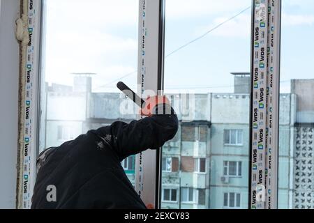 Tiraspol, Moldova - March 2, 2021: Installation of windows. The builder installs a pvc window brand WDS in the apartment of an apartment building. Stock Photo