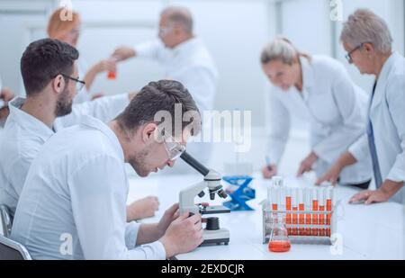 group of scientists using microscopes to study blood. Stock Photo
