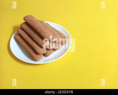 Sweet soft healthy soft spongy sprinkled sugar vanilla cookies (vainillas). Classic Argentine biscuits. Yellow background. High angle shot. Copyspace Stock Photo