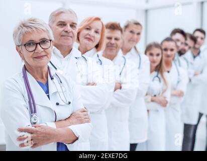 senior female doctor standing in front of her colleagues. Stock Photo