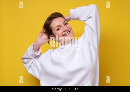 Young caucasian woman wearing hoody relaxing and stretching, arms and hands behind head and neck smiling happy Stock Photo