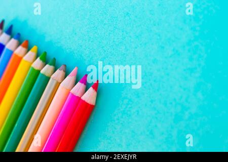 Many different colored pencils with turqoise background Stock Photo