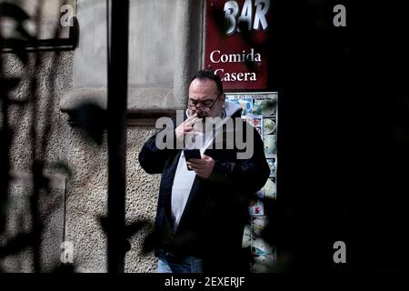 Man smoking and looking at his mobile phone, Barcelona, Spain. Stock Photo