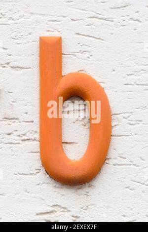 Orange letter b on a white house wall Stock Photo