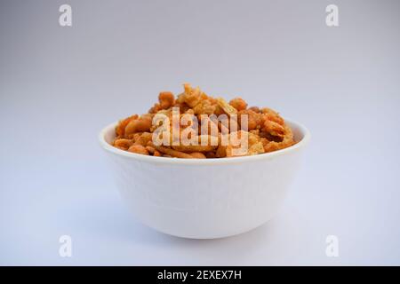 Indian namkeen snacks served in ceramic white bowl no white background isolated. Also known as nimco, namkin, mixture chiwda or nimko Stock Photo