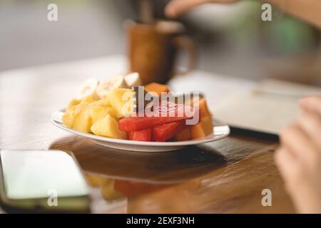 Selective focus on a dish with cut fruit salad and a fork on it Stock Photo