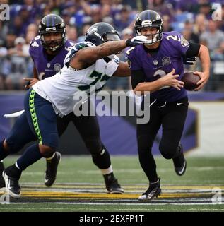 Baltimore Ravens' quarterback Jimmy Clausen passes under heavy