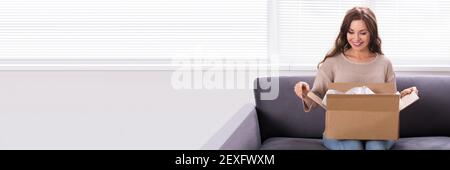 Woman Receiving Parcel Or Delivery Package. Opening Gift Stock Photo