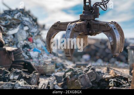 Close-up view on mechanical arm claw of crane at landfill. Stock Photo