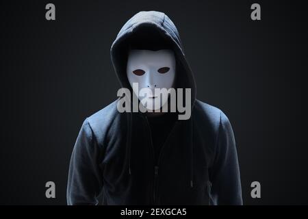 Masked anonymous hacker on black background. Stock Photo