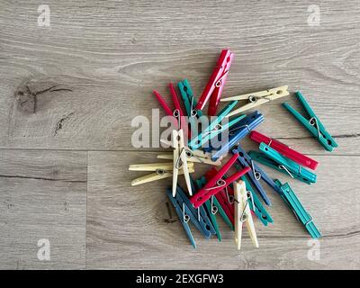 FRESNO, UNITED STATES - Feb 22, 2021: An over head view of different colored plastic clothes pins on grey colored rustic wood background Stock Photo