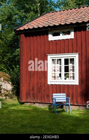 Empty chair in sunlight alongside a timber house Stock Photo