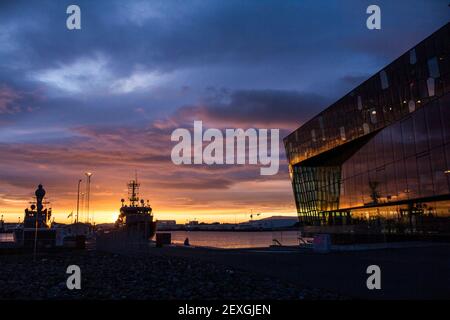 Sunset over Harpa concert hall and the harbor of Reykjavik in Iceland Stock Photo