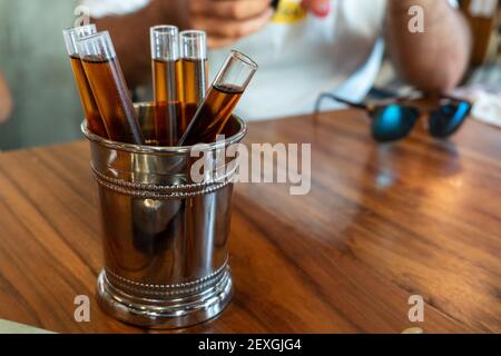 A closeup shot of five shots of wine in test-tube-shaped glass offered after lunch in Sevilla, Spain Stock Photo
