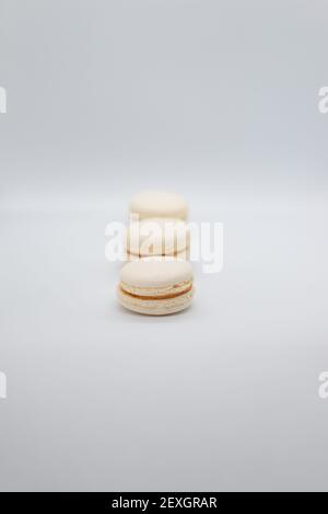 Close-up of macaroons in row over white background. Copy space Stock Photo