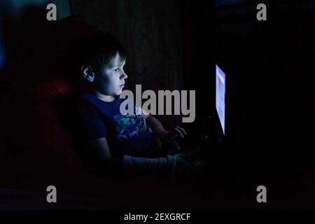 Portrait of teen boy using laptop by window Stock Photo - Alamy