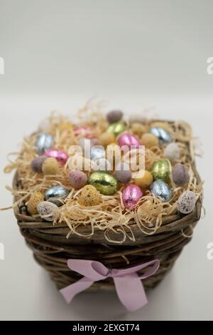 A lot of different shape Easter eggs in the basket full of hay. Stock Photo