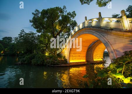 Arched pedestrian bridge at the lake in the the centre of Guilin Stock Photo