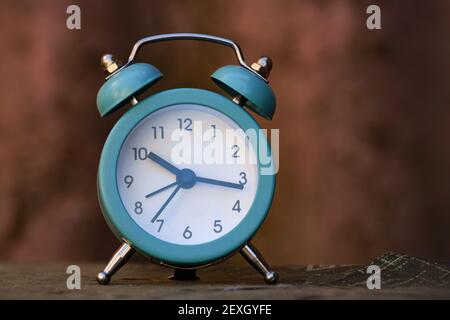 A blue alarm clock on the table Stock Photo