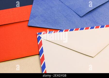 A closeup shot of different colored various postal envelopes on a ta Stock Photo