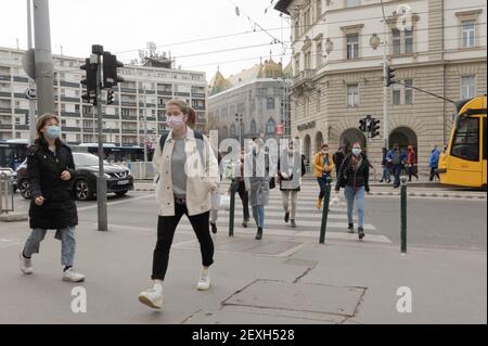 Budapest, Hungary. 4th Mar, 2021. People wearing face masks walk on a street in Budapest, Hungary, on March 4, 2021. The Hungarian government presented on Thursday a set of stricter rules in order to combat the third wave of the pandemic, as daily new infections surpassed 6,000, a level unseen since last November. Credit: Attila Volgyi/Xinhua/Alamy Live News Stock Photo