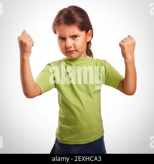 Angry evil girl shows fists experiencing anger and emotion Stock Photo