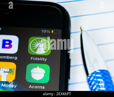 MINNEAPOLIS, MINNESOTA / USA - MARCH 4, 2021: Person using Apple i-phone to press and access the Fidelity logo app / application Stock Photo