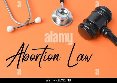 Judge gavel, stethoscope over orange background written with ABORTION LAW. Stock Photo