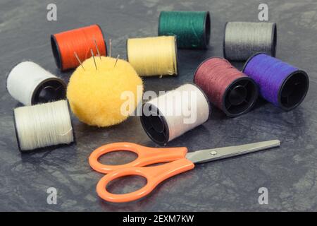 Accessories and tools for using in sewing and needlework. Spools of thread, needle, scissors Stock Photo