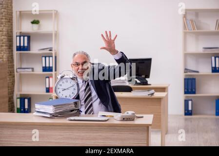 Senior businessman employee in time management concept Stock Photo