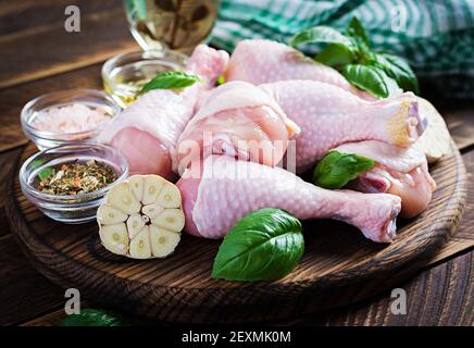 Raw chicken drumsticks with spices. Raw chicken legs with spices on a wooden  background. Stock Photo